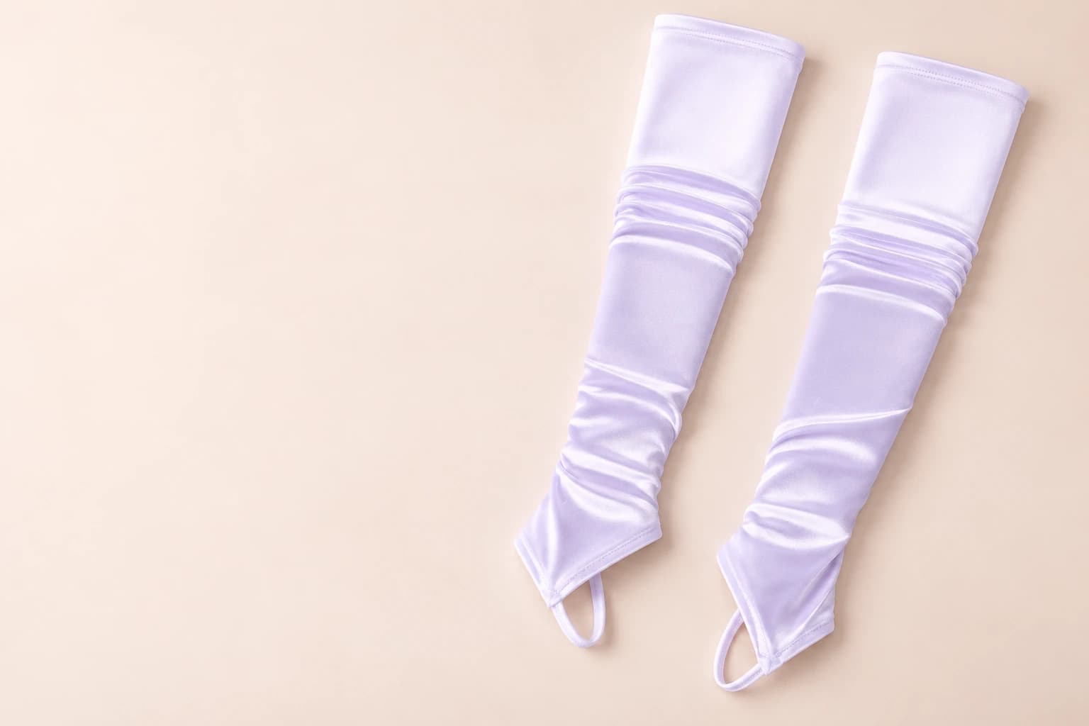 Pale lilac ruched fingerless arm sleeves with thumb loops on a soft blush studio surface